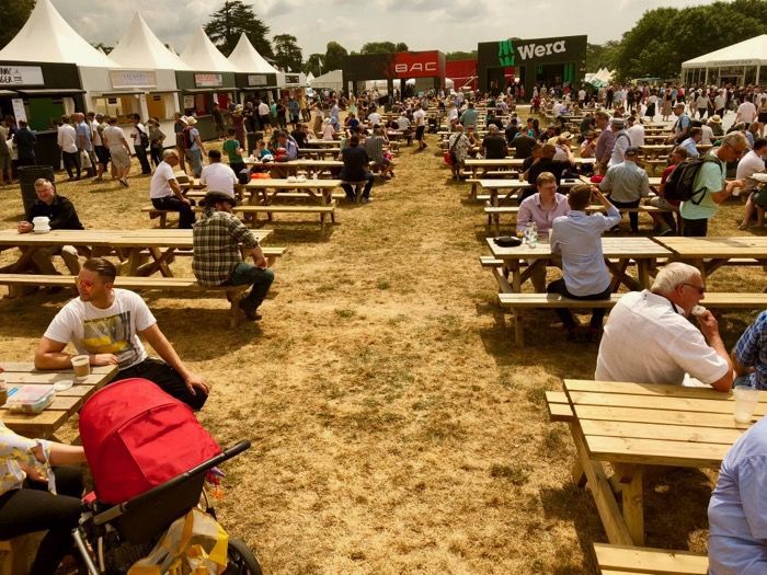 Picnic tables in use at a busy outdoor event